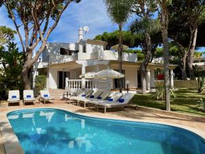 a villa with a swimming pool in front of a house at Vale Do Garrao Villas in Vale do Lobo