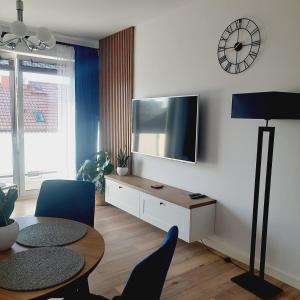 a living room with a table and a tv on a wall at Lux Apartment parking gratis in Złotów