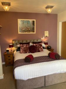 a bedroom with a large bed with red pillows at The Quies in Newquay