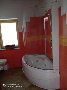 Torrent du Chateau casa vacanze في أَويستا: حمام احمر مع حوض استحمام ومرحاض