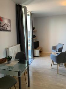 ein Wohnzimmer mit einem Glastisch und Stühlen in der Unterkunft Einraumapartment mit Seeblickbalkon in Rheinsberg