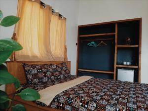 a bedroom with a bed with a quilt on it at Le Hublot in Cotonou