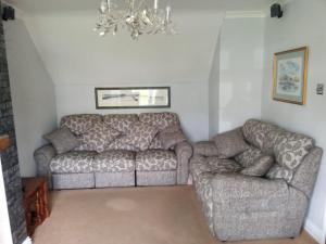 a living room with two couches and a chandelier at Beautiful, Seaview house in Whitstable in Kent