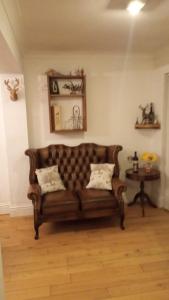 a living room with a brown couch and a table at Beautiful, Seaview house in Whitstable in Kent