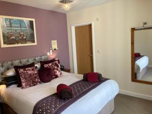 a bedroom with a large bed with a mirror at The Quies in Newquay