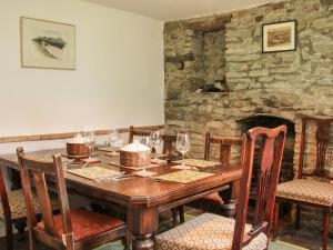 uma sala de jantar com uma mesa de madeira e copos de vinho em Denbigh Hall em Leominster