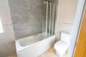 モルトンにあるDeneb Lodge with Hot Tubのトイレ、浴槽、洗面台を備えたバスルーム