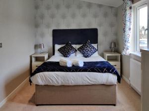 モルトンにあるDeneb Lodge with Hot Tubのベッドルーム1室(大型ベッド1台、枕2つ付)