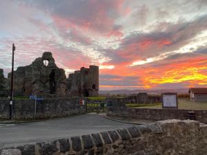 an old castle with a sunset in the background at Riverdale Cottage in Rhuddlan