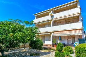 a building with trees in front of it at Apartment Kelly in Novalja