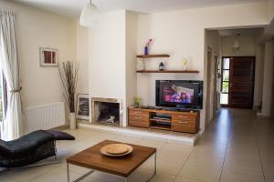 a living room with a television and a table at Villa Hera in Ayios Theodhoros