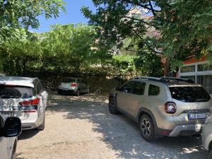 two cars parked in a parking lot next to a house at Apartments Lea in Orebić
