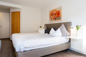 ein Schlafzimmer mit einem großen Bett mit weißer Bettwäsche in der Unterkunft Hotel La Fleur in Überlingen