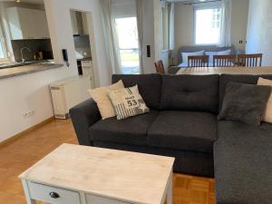 a living room with a gray couch and a kitchen at Ferienwohnung Elzblick in Rust