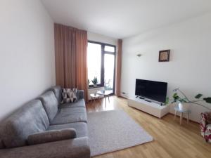 a living room with a couch and a flat screen tv at Pirita Sea View Apartments One bedroom in Tallinn