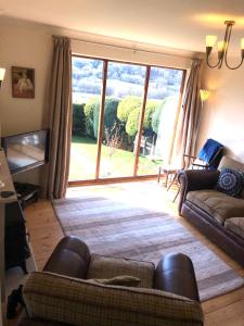 a living room with a couch and a large window at Derwent View in Bamford