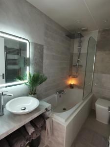 a bathroom with a sink and a tub and a toilet at Sunrise View 2 Bed Apartment Sleeps 4 Spa Bath in Bridlington