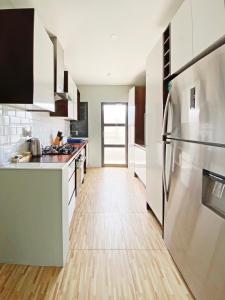 a kitchen with a stainless steel refrigerator and wooden floors at GreyStone Apartments in Nadi