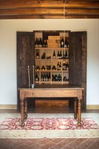 una mesa en una habitación con una estantería de botellas de vino en San Calisto camere con vigna, en Popoli