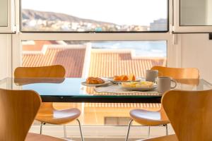 een tafel met eten en stoelen voor een raam bij El Cabezo Médano 1ª Linea in El Médano
