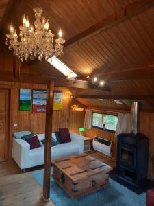 a living room with a couch and a chandelier at fraai chalet Barvaux in Durbuy