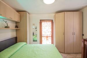 Un dormitorio con una cama verde y una ventana. en Apartment just close to the Lake in Bellagio, en Bellagio