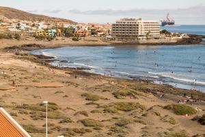 een groep mensen op een strand vlakbij de oceaan bij El Cabezo Médano 1ª Linea in El Médano