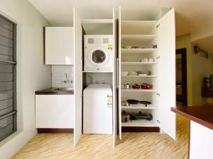 a kitchen with a refrigerator and a washing machine in it at GreyStone Apartments in Nadi