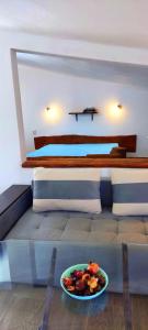 a bedroom with a bed with a bowl of fruit on a table at АПАРТАМЕНТ АРГАНТОНЕ in Sinemorets
