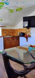 a kitchen with a glass table with a bowl of fruit on it at АПАРТАМЕНТ АРГАНТОНЕ in Sinemorets