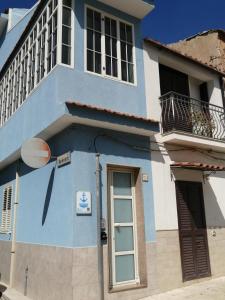 un edificio blu e bianco con finestra di Borgata Mazzarelli a Marina di Ragusa