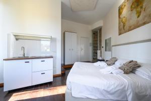 ein Schlafzimmer mit einem weißen Bett und einem Waschbecken in der Unterkunft Relais Incantesimo Vaticano in Rom