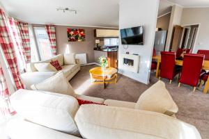 ein Wohnzimmer mit weißen Sofas und ein Esszimmer in der Unterkunft Ryedale Lodge with Hot Tub in Malton