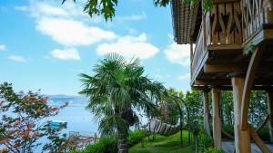 a palm tree next to a building with a view of the water at SASA Harmanlık in Sapanca
