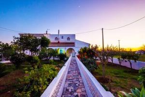 a walkway in front of a house with a building at Vivenda Aromas do Algarve in Monte Raposo