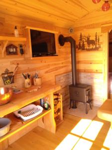a kitchen with a stove in a log cabin at Au Paradou du Bûcheron Adults only in Lessive