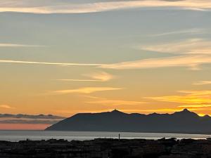 un tramonto su una città con una montagna sullo sfondo di Ulisse's LOFT - Incantevole vista mare, centro storico e spiaggia a piedi - wifi a Terracina