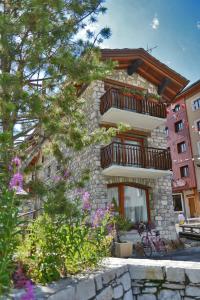 un edificio con balcones y flores delante de él en L'Annexe, en Val dʼIsère