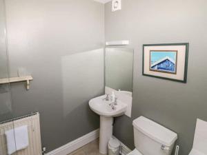 a white bathroom with a sink and a toilet at Wetton Barns Holiday Cottages in Ashbourne