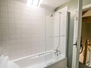 une salle de bain avec une douche avec une porte vitrée dans l'établissement Wetton Barns Holiday Cottages, à Ashbourne
