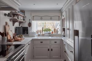 una cucina con armadietti bianchi e una finestra di Little Nut Cottage ad Ambleside