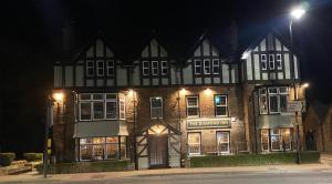 庞蒂兰The Diamond Inn的一座大型砖砌建筑,晚上有灯