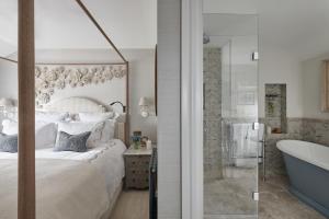 een slaapkamer met een bed en een bad naast een badkamer bij Little Nut Cottage in Ambleside