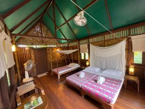 a bedroom with a bed and a green ceiling at Our Jungle Camp - Eco Resort in Khao Sok