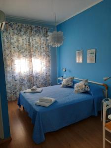a blue bedroom with a blue bed with towels on it at Affittacamere Mirella in Pineto