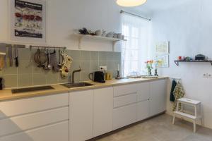 a kitchen with white cabinets and a sink at Lilie House in Bormes-les-Mimosas