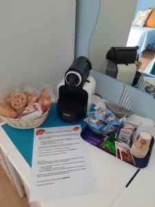 a table with a coffee maker and a basket of food at Affittacamere Mirella in Pineto
