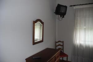 a room with a desk and a mirror and a television at Costa Verde in Vila Nova de Cerveira