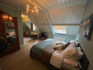een slaapkamer met een bed en een kroonluchter bij Villa Rozenhof in Almen