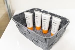 a basket with four bottles of sunscreen on a table at Apartament Przystań Gdynia by Renters in Gdynia